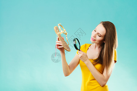 精美的夏季购物销售概念时装女选择用放大镜搜索鞋子图片