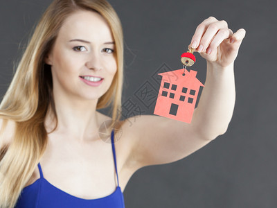 持有新房钥匙红色家庭形状不动产和住房概念图片