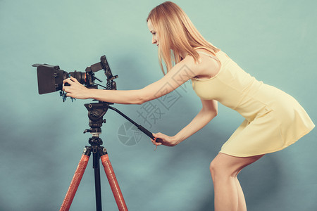 摄影女师拍图片有吸引力的时尚髦金发女郎拍摄相机蓝背景照片图片