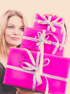 带着一大堆粉红礼物盒的快乐年轻少女背景图片
