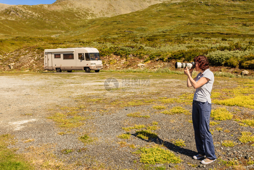 旅游度假和旅游女游客用相机拍照背景是露营车旅游线路Aurlandsfjellet山地露营车和带相机的游客图片