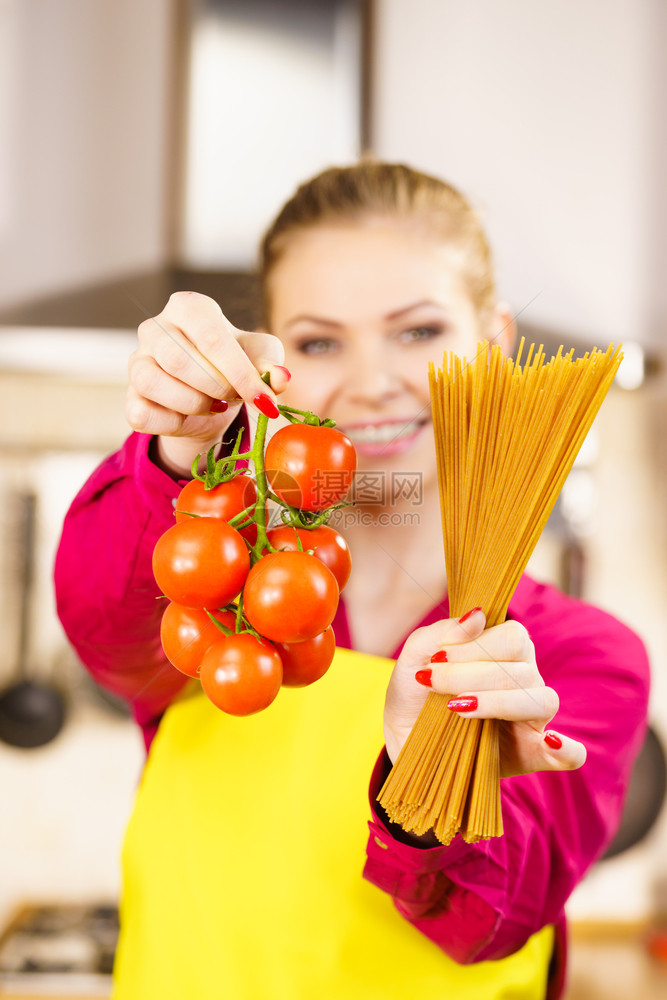 持有长面纱和新鲜有机美味西红柿的女即将烹饪意大利面图片