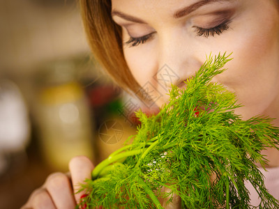 持有草药的年轻女拥有草的漂亮女闻到它的气味图片