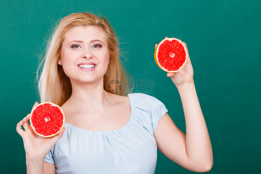 女微笑的孩将两半红葡萄果柑橘握在手中放绿色上健康饮食品暑假乐趣概念女将葡萄果握在手中图片