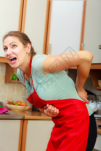 患有背痛的少女在厨房中年女背痛的少在厨房中年女图片