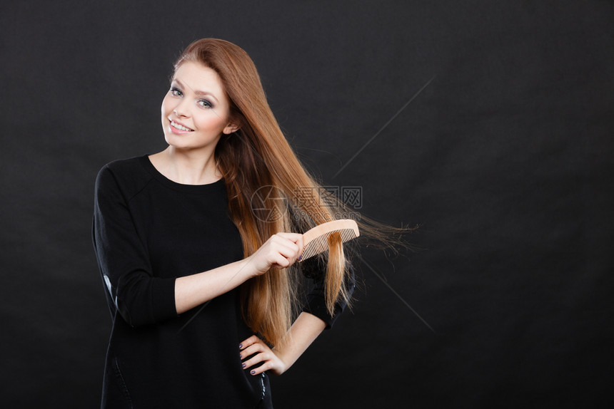 健康的外观概念女孩用木梳理头发年轻女照顾日常卫生和自然美貌长发女梳理头图片