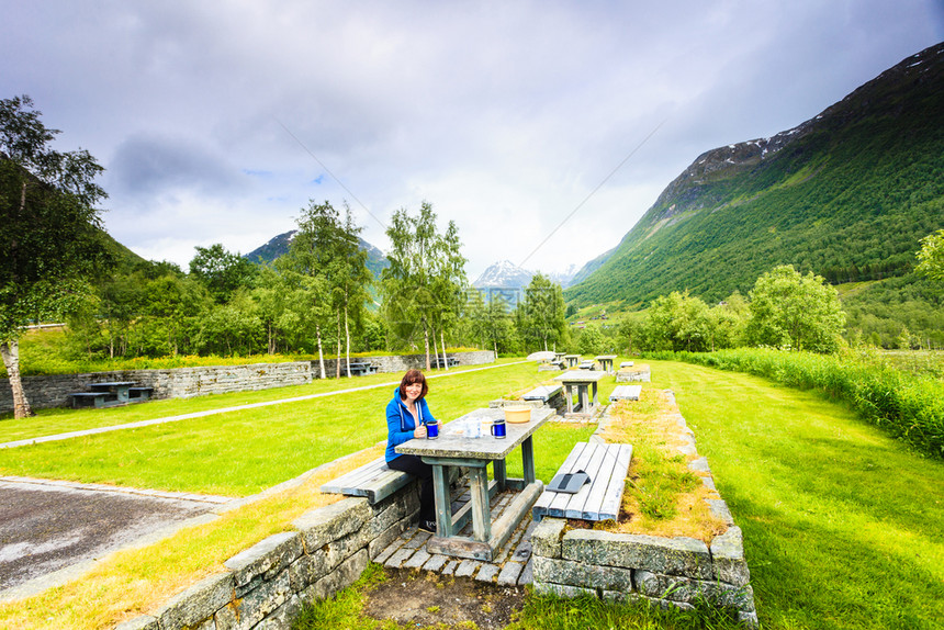 在斯堪的纳维亚欧洲诺韦吉山区旅行妇女吃大自然的午餐在挪威山区旅行妇女吃大自然的午餐图片