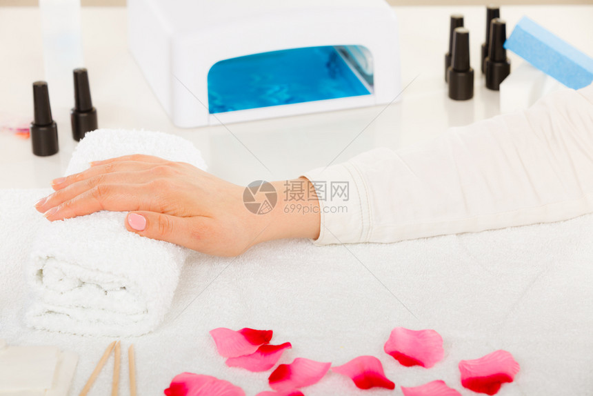 女手在毛巾上等待凝胶混合修指甲美健康水疗法概念女手在毛巾上紧靠修指甲图片