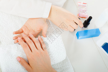 女手在毛巾上等待凝胶混合修指甲美健康水疗法概念女手在毛巾上紧靠修指甲背景图片