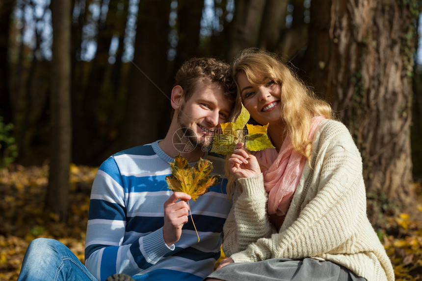 年轻浪漫情侣在阳光明媚的白天在秋公园放松图片