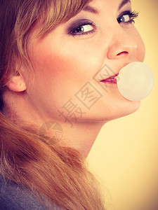 甜食和糖果乐趣欢年轻的金发女孩喜欢吃甜食口香糖做气球的快乐女人图片