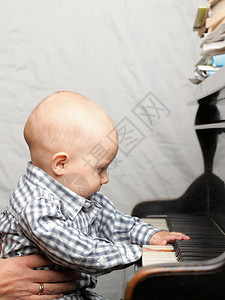美丽的小男孩学习弹钢琴图片