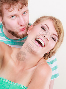 爱着情侣欢笑的着女人和男亲吻他的女朋友脸颊图片