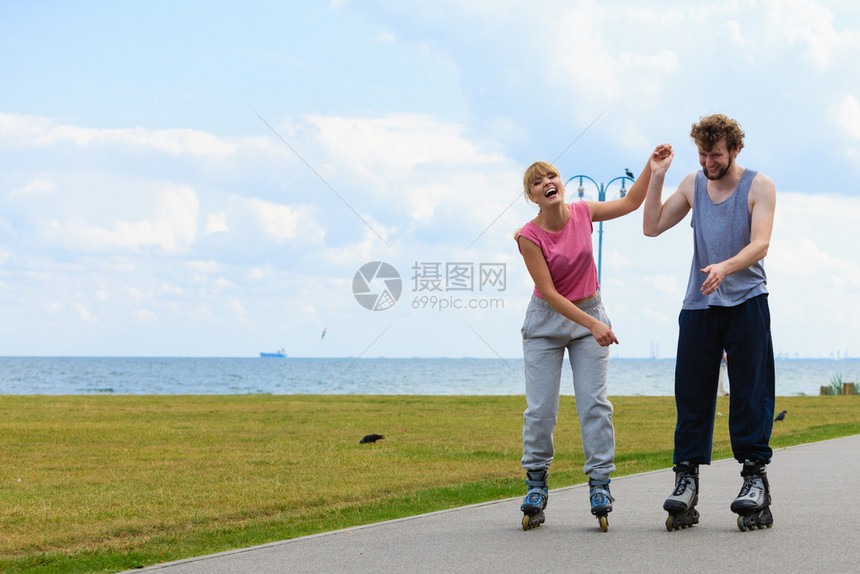 活跃的节日锻炼关系概念年轻男女穿着运动式的服装手握双在赛道上拉着滚轮图片