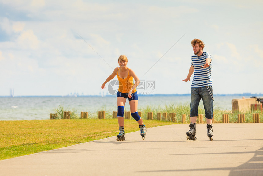 在户外玩轮滑鞋的年轻情侣图片