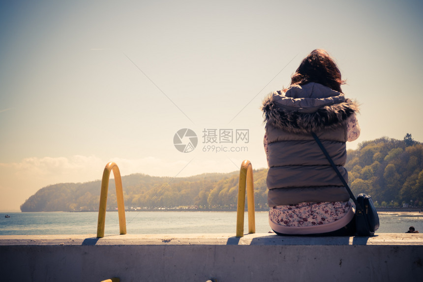 坐在码头的孤单思考女人着在想上欣赏大自然的美丽图片