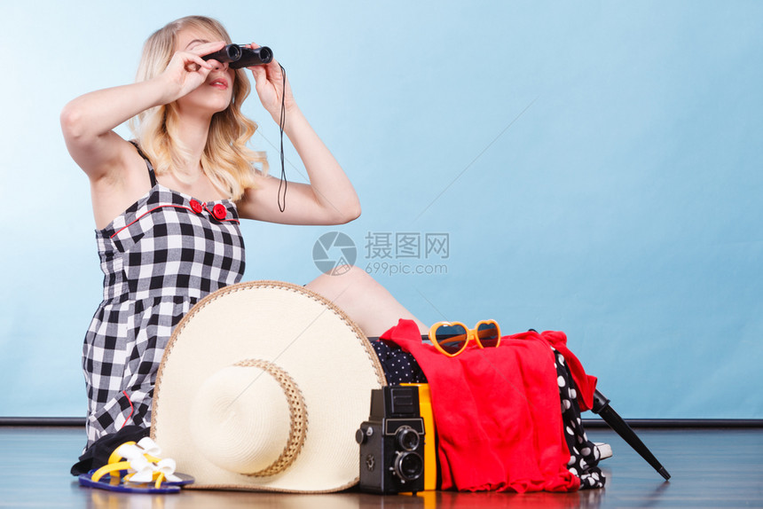 女人透过望远镜看坐在地板上拿着手提箱装满东西准备放暑假图片
