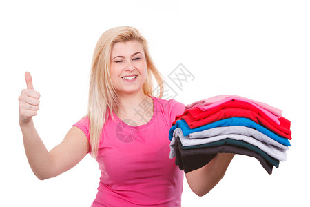 家务完美庭主妇概念女洗完衣服后拿着一堆折叠衣服用拇指熨烫手势图片