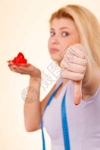 女人带着草莓糖蛋糕手缩势女人拿着草莓糖蛋糕背景图片