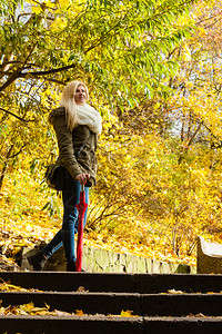 妇女走过秋季公园时站在楼梯上妇女站在秋季公园的楼梯上图片