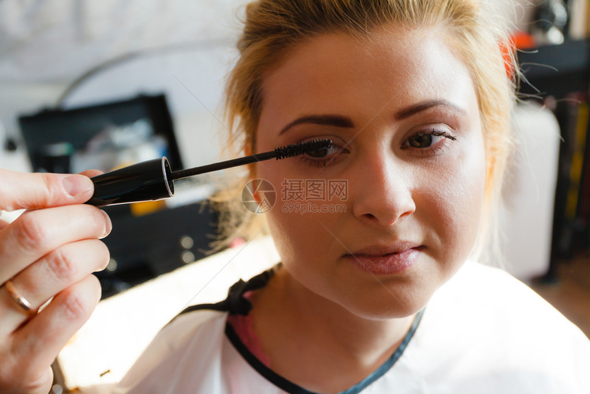 近视镜美容概念女脸部的近视肖像由专业艺术家用马斯卡拉做眼睫毛化妆图片