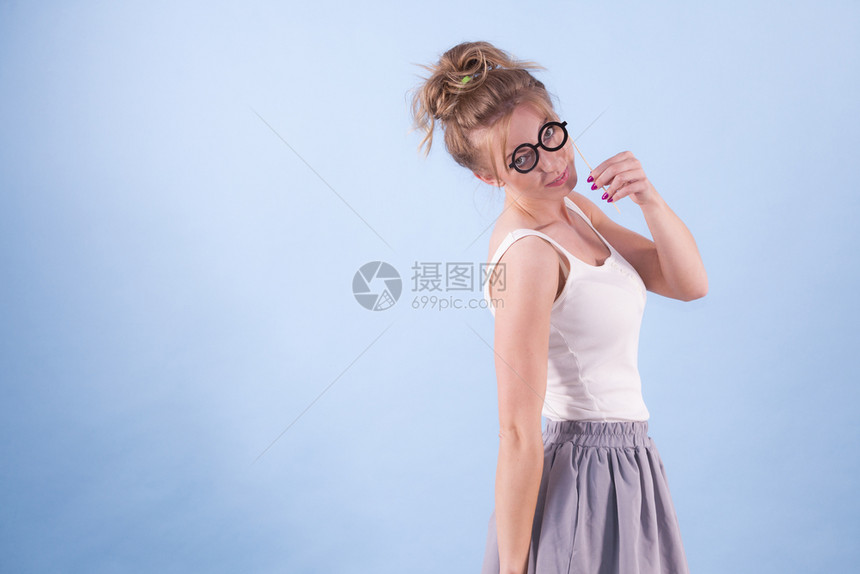 优雅的年轻女子假装戴着有趣的书呆子眼镜教育与学习女观假装戴眼镜的优雅女人图片