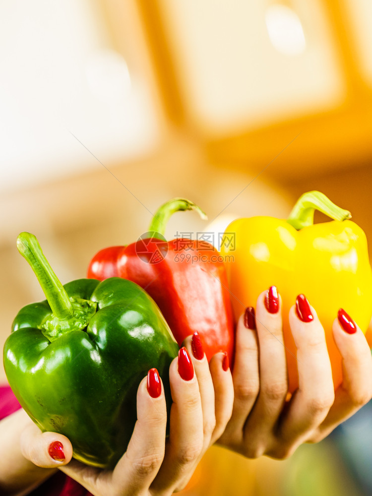 妇女手握胡椒辣美味健康饮食蔬菜以三种颜色展示饮食物妇女握着辣椒图片