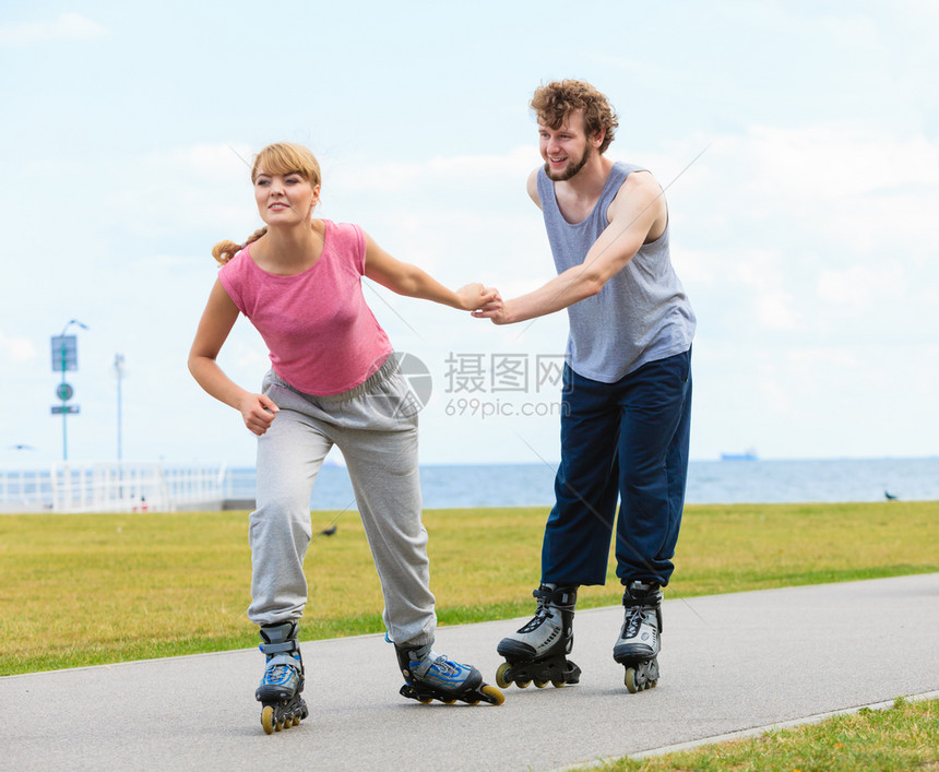 活跃的生方式和自由概念穿溜冰滑雪的年轻情侣在海边户外玩滑冰男女一起享受时间图片