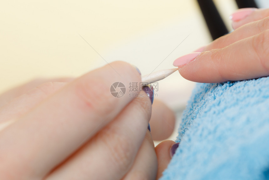 女美容师在修指甲前准备钉子用木棍推后切片美师在修指甲前准备钉子推后切片图片