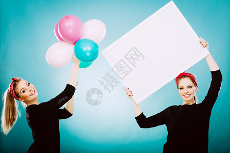 欢笑的姑娘们拿着展示板旗帜标志和彩色气球玩得开心图片