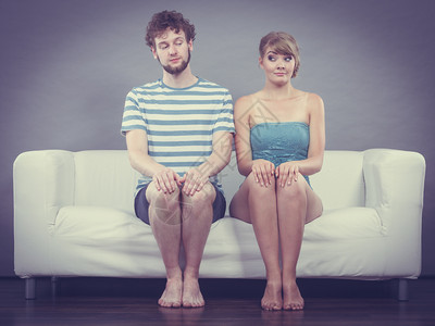 关系概念沙发上坐在一起的女和男关系很亲密图片