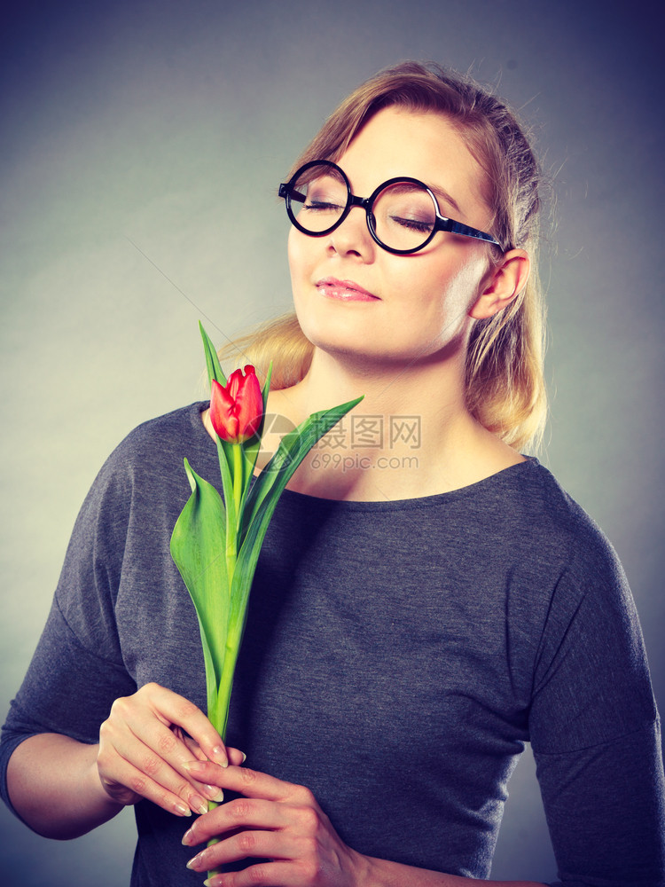 美丽的可爱女孩闻着美丽的春花可爱女孩的甜女人红色的绿郁金香女士闻到大自然的味道迷人鲜花闻到平静图片