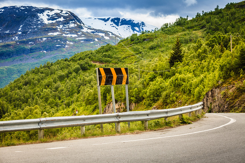 路标横穿夏季挪威山阳光明媚的天气下美丽绿色自然景观背森林挪威山路图片