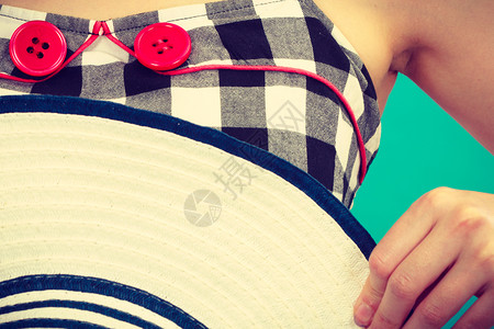 穿旧礼服的妇女检查了黑白礼服有两个红色扣子戴太阳帽图片