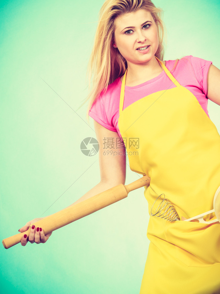 穿黄色围裙的妇女拿着滚动针准备做饭图片