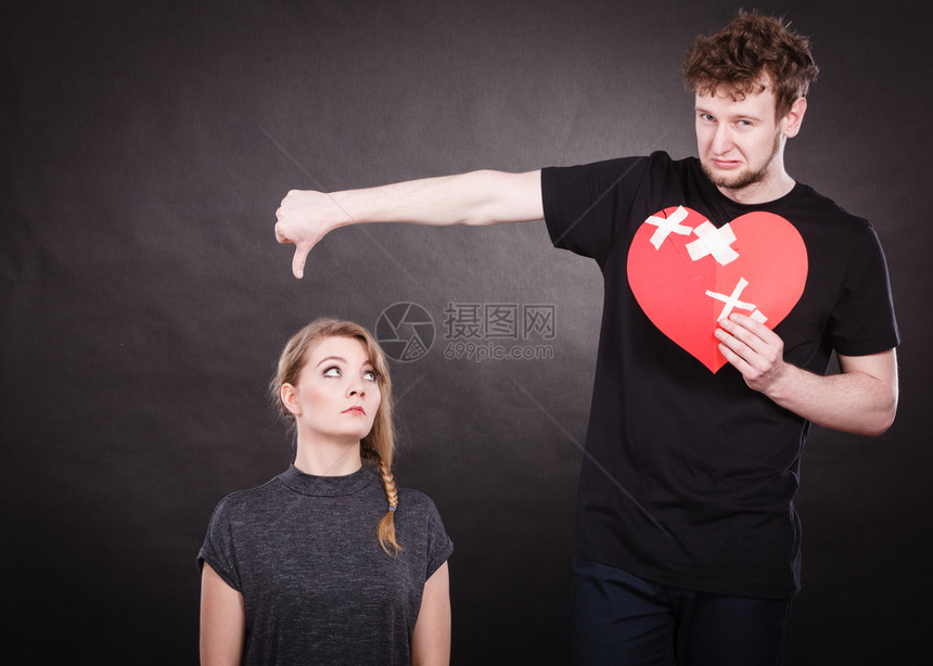 心碎难恋的概念伤心不幸福的夫妻男女手拿纸红心用石膏绷带固定关系裂痕伤心的夫妻抱着破碎的心图片