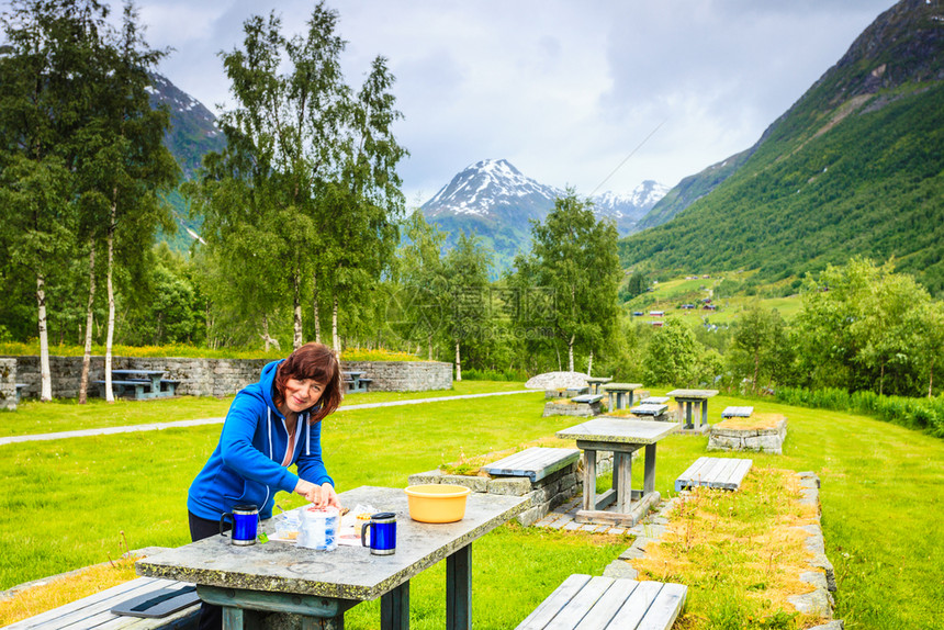 在斯堪的纳维亚欧洲诺韦吉山区旅行妇女吃大自然的午餐在挪威山区旅行妇女吃大自然的午餐图片