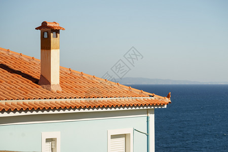 房屋顶上最小型高的烟囱与蓝色天空相对房屋顶上最高的烟囱图片
