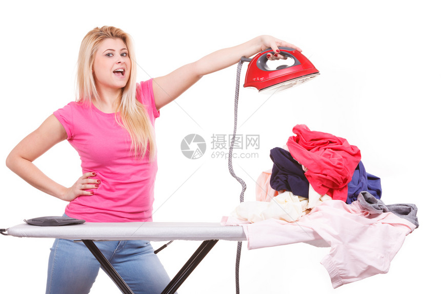 家务照顾房子的概念站在板后面拿着熨斗的女人有一堆衣服要熨拿着熨斗准备熨衣服的女人图片
