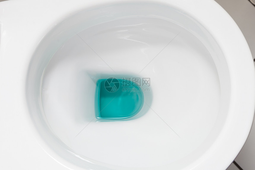 清洁和消毒概念白色厕所碗里面有蓝色洗涤剂图片