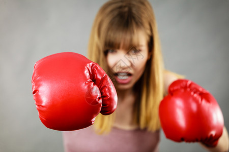 身着红拳击手套打斗身穿拳击手套的女运动员背景图片