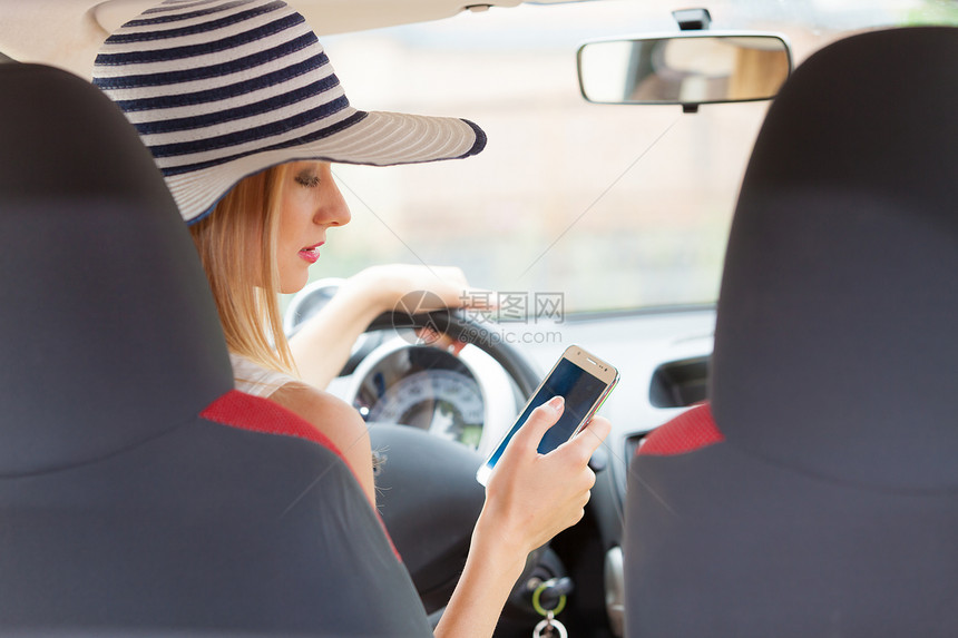 驾驶汽车时使用手机发短信或读息驾驶汽车时使用电话的妇女图片