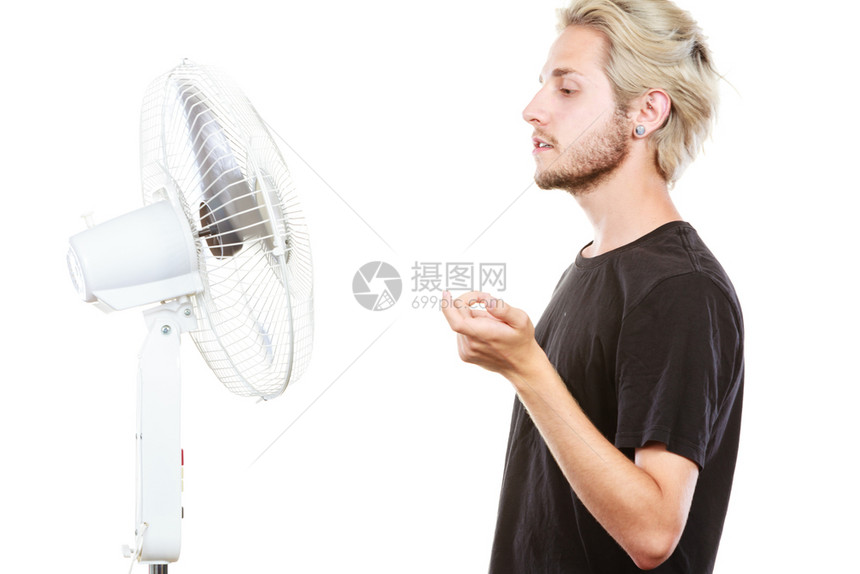年轻人站在冷却风扇前艺术方式工作室拍摄被孤立年轻人站在冷却风扇前图片