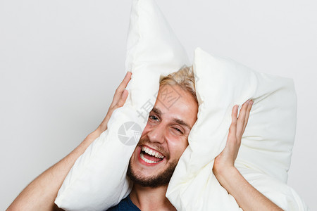 快乐的年轻人睡得安后玩着低沉的垫子笑着玩得开心男人玩枕头睡得安图片