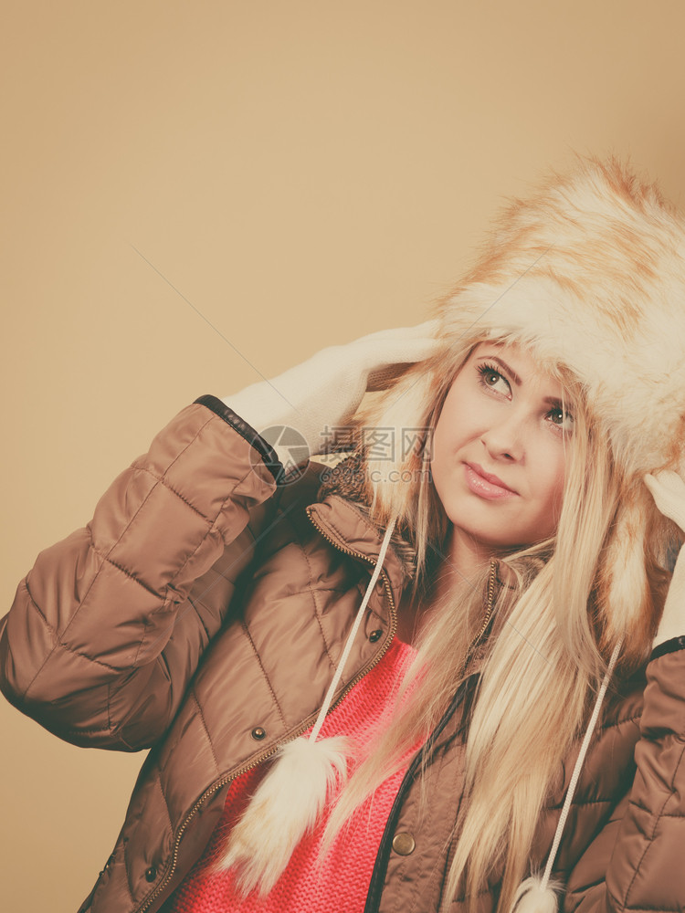时装概念寒冷穿衣服的套件冬金发女人穿着俄罗斯风格的暖毛帽图片
