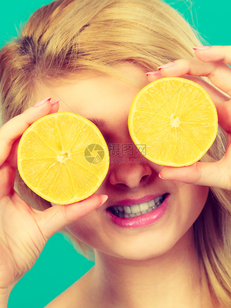 健康饮食新鲜物充满维他命女人拿着甜的柑橘水果柠檬两半假装是眼镜女人拿着水果柠檬一半在眼睛上图片
