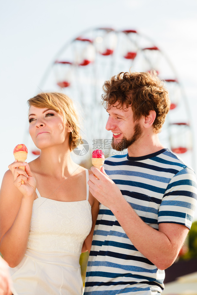 暑假和快乐概念年轻夫妇在游乐园吃户外冰淇淋图片
