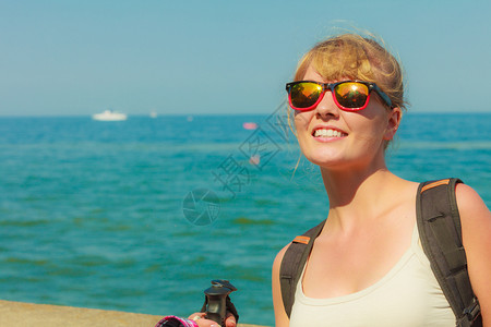 冒险旅游享受暑假在海滨背包徒步旅行的年轻游妇女图片