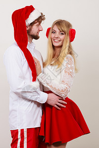 笑得开心的一对可爱情侣穿着圣诞礼帽的漂亮女人和男图片