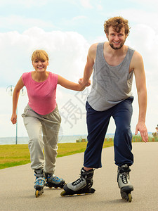 和朋友一起滑冰活跃的生方式和自由概念穿溜冰滑雪的年轻情侣在海边户外玩滑冰男女一起享受时间背景